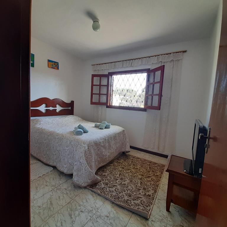 坎波斯杜若尔当Casa Quintanilha的一间卧室设有一张床、一个窗口和一台电视