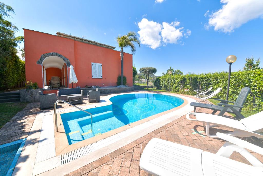 伊斯基亚Villa Stefania的一个带椅子的游泳池以及一座房子