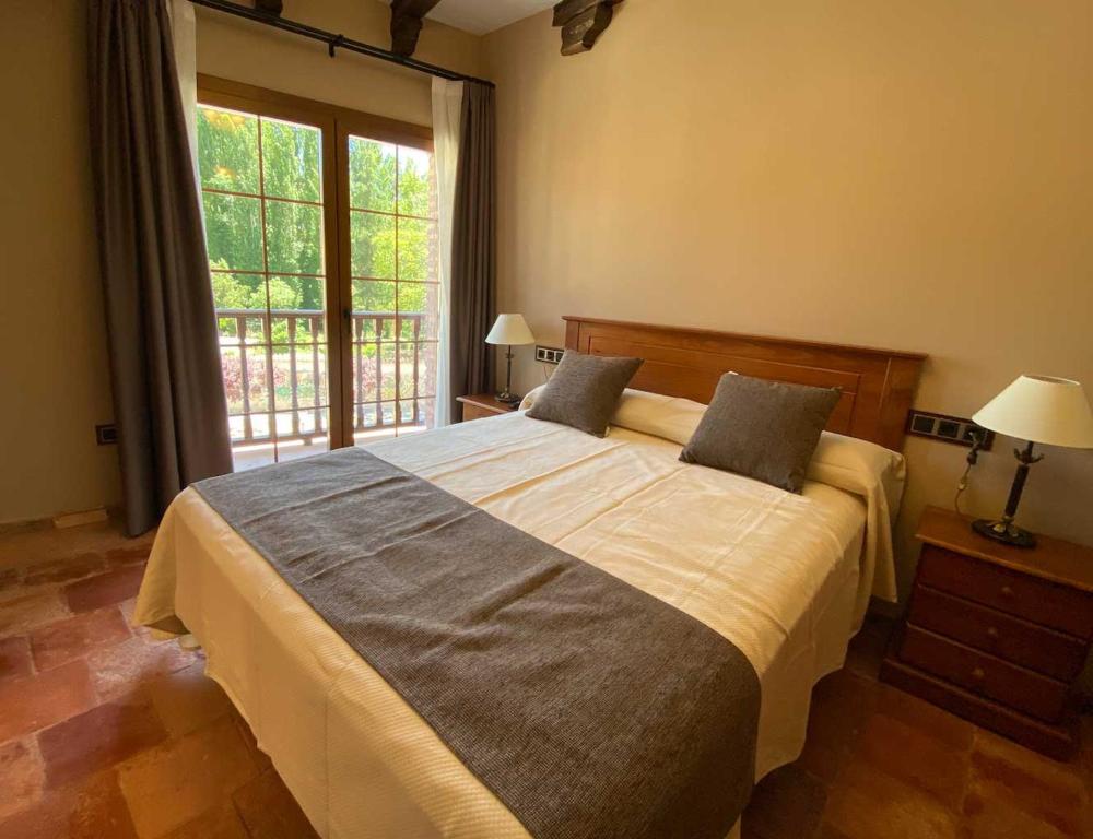 Perales de TajuñaHotel Rural El Lagar de Nemesio的一间卧室设有一张大床和一个窗户。