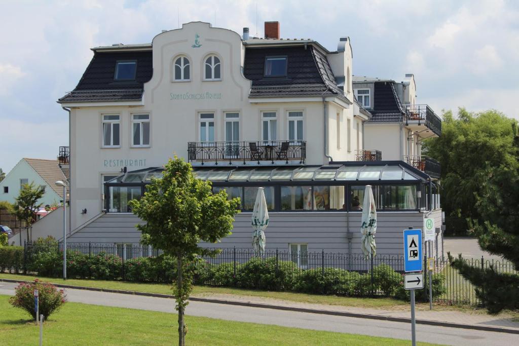 伯尔格伦德-雷特维施阿里尔海滩城堡旅馆的前面有标志的大型白色建筑