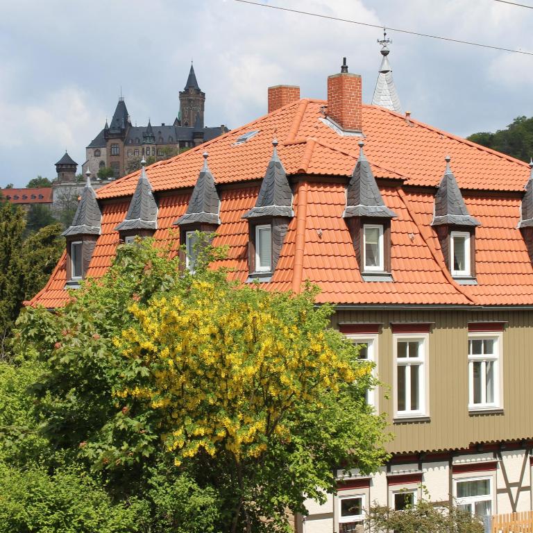 韦尼格罗德Villa Schlossblick的一座拥有橙色屋顶和树的建筑