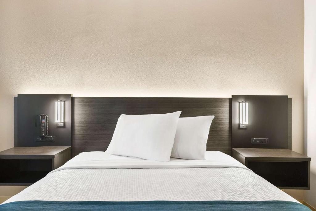 Mountlake Terrace西雅图6号公寓酒店 - 芒特莱克泰勒斯的一间卧室配有一张带两个床头柜和四柱床的卧室