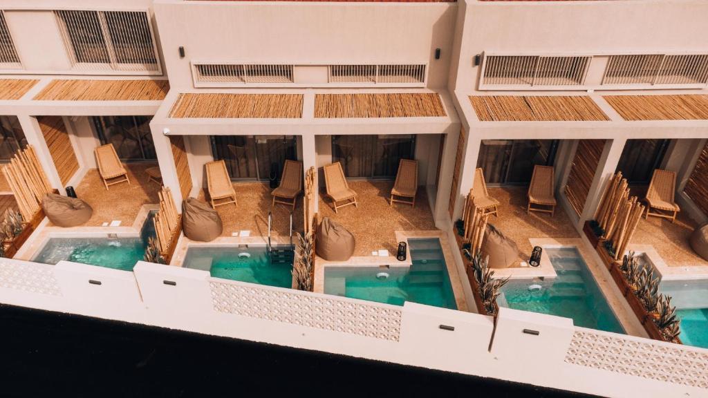 波利克罗诺Amoessa Boutique - Adults Only的享有带2个游泳池和椅子的大楼的顶部景致