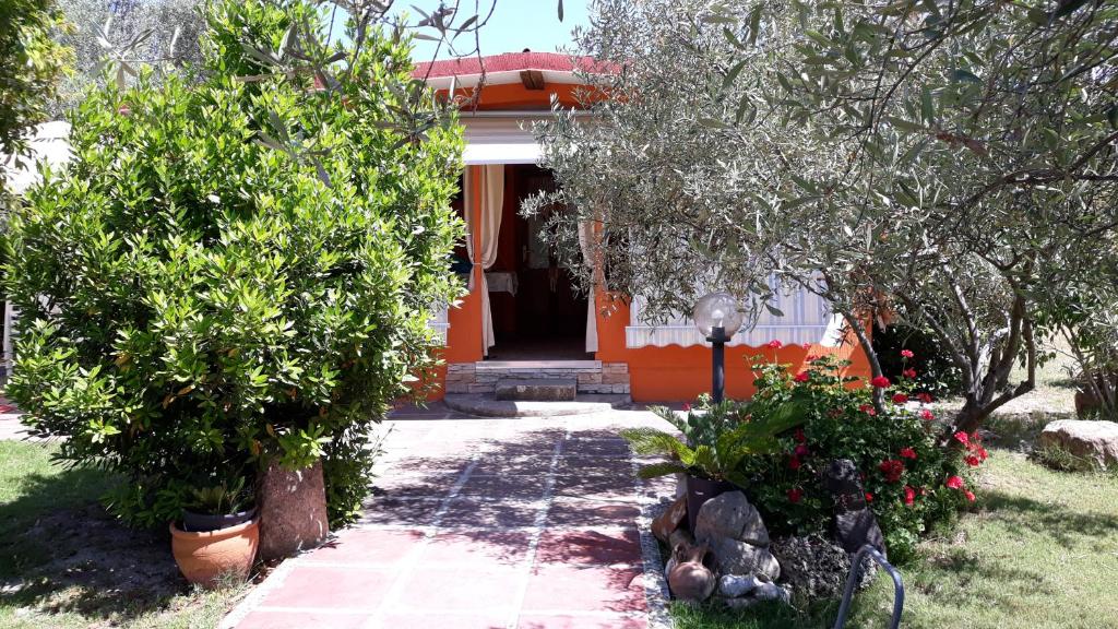 普拉Casa Vacanza Gaia Relax Pula的一座橘色房子前面有树木和鲜花