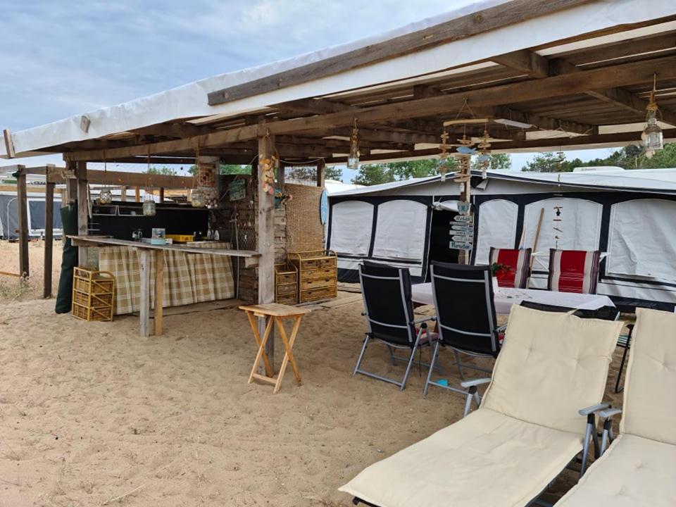 索佐波尔Ultimate Caravan Experience - 1st Line Gradina的海滩上的帐篷,配有椅子和桌子