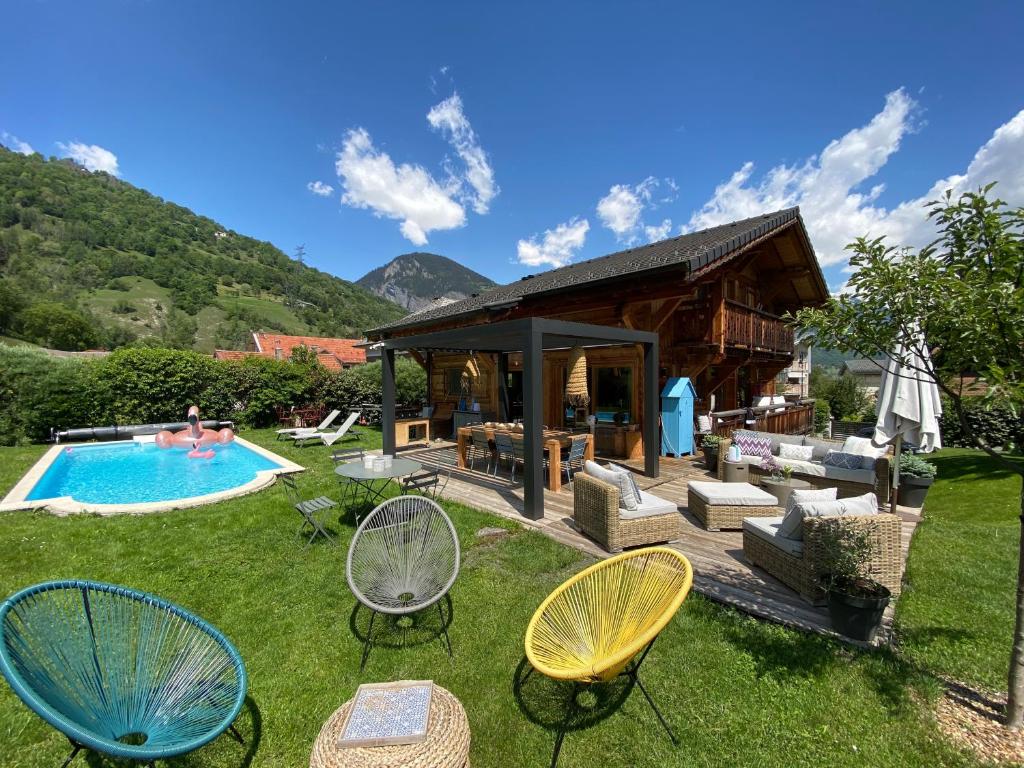 圣莫里斯堡Grand chalet à la montagne的后院设有游泳池、椅子和房屋