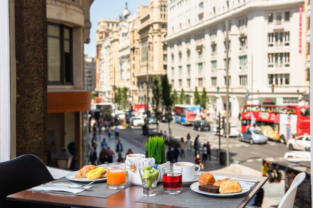 马德里Hotel Madrid Gran Via 25, Affiliated by Meliá的一张桌子,上面有两盘食物,放在城市街道上
