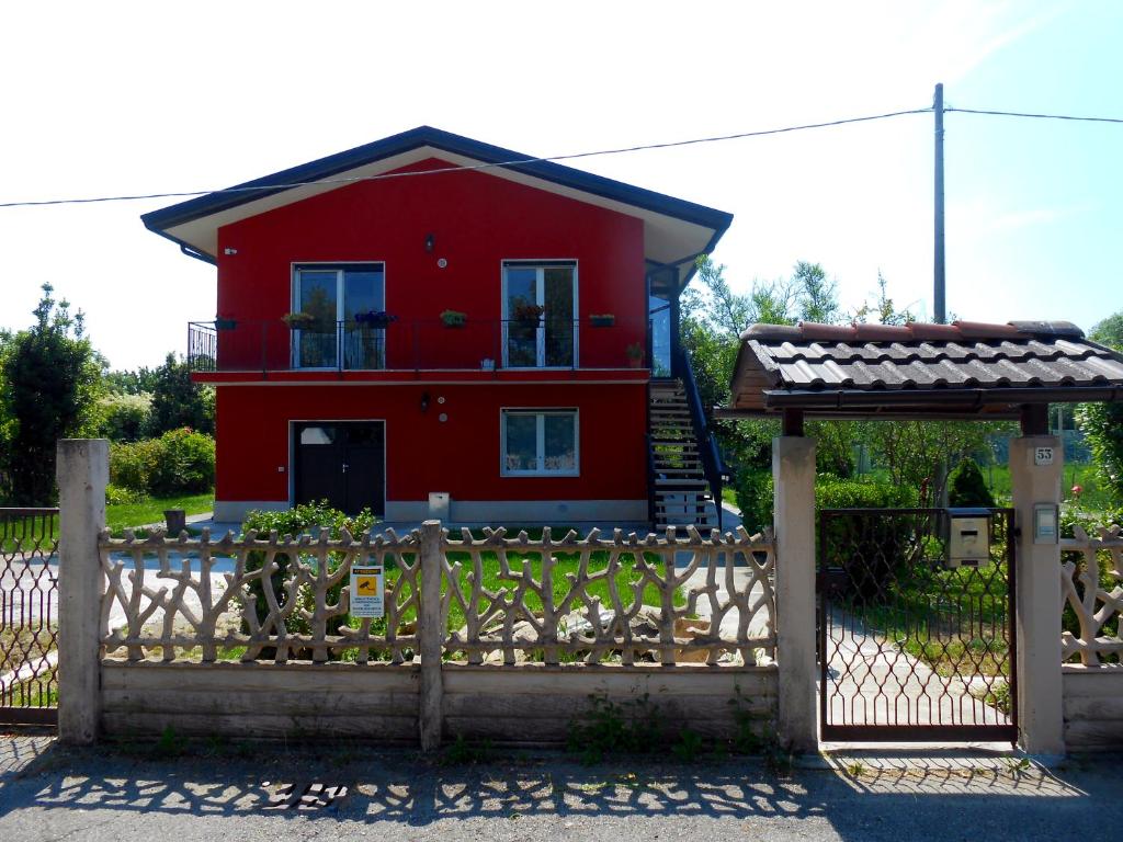 泰塞拉VCE House的栅栏后面的红色房子,有门