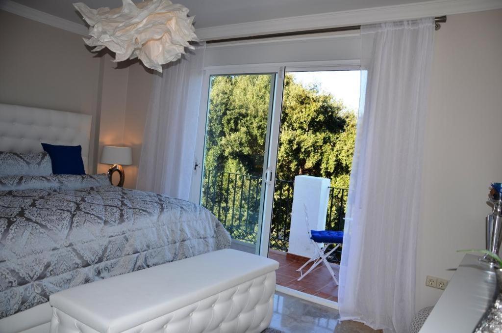 奥亨Penthouse mit privatem Jacuzzi in Marbella - La Mairena的一间卧室设有一张床和一个滑动玻璃门