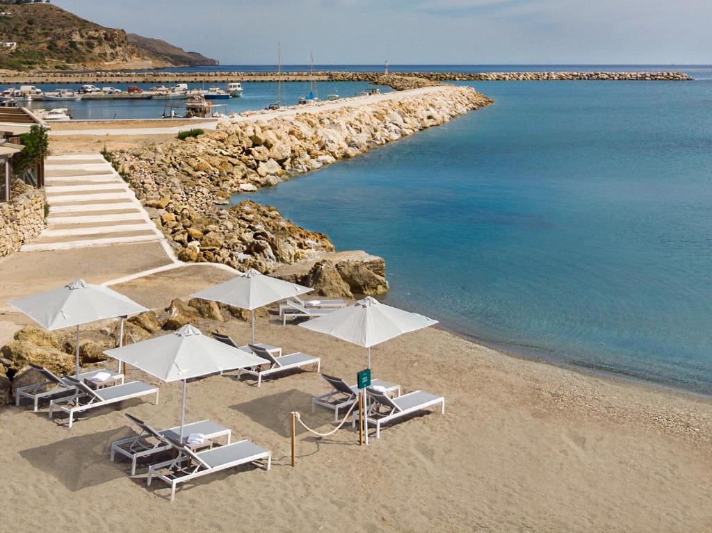 科林瓦里奥Kolymbari Sea Front Cozy Apartments的海滩上设有椅子和遮阳伞,水面