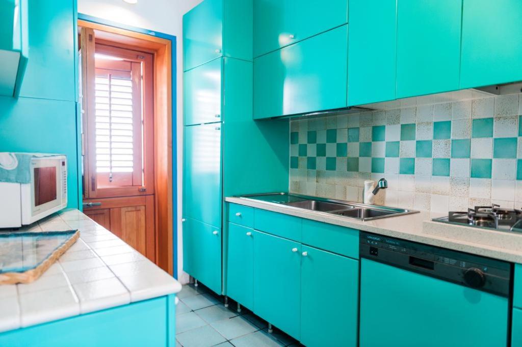 马里迪莫Acquamarina guest house的绿色厨房配有蓝色橱柜和水槽
