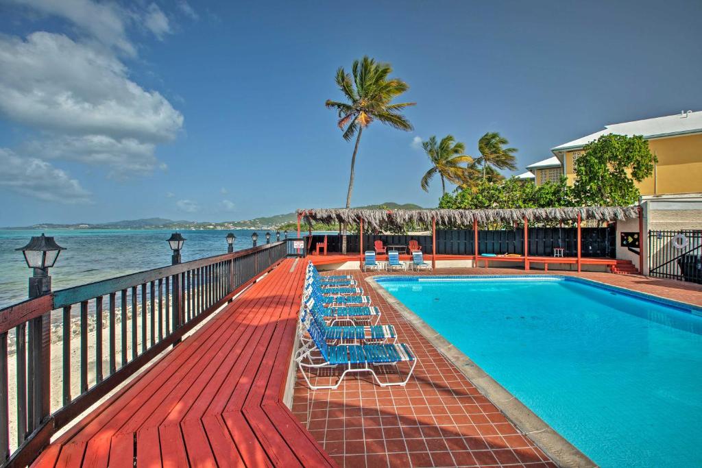 克里斯琴斯特德Beachfront St Croix Condo with Pool and Lanai!的毗邻大海的带躺椅的游泳池