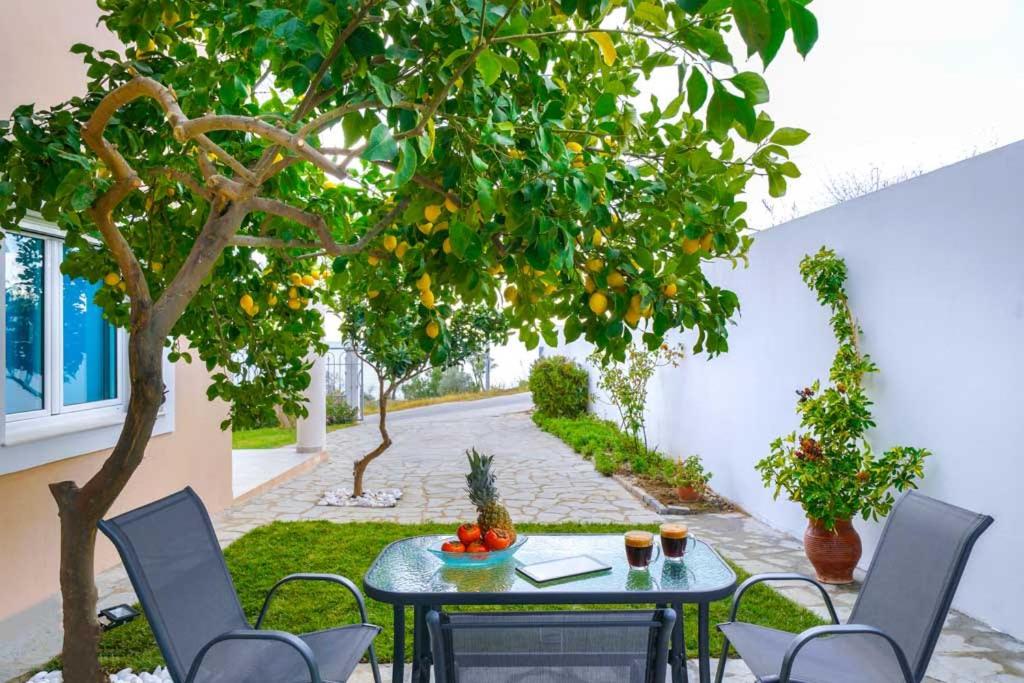 利迈纳里亚El Mare Seaside Retreats - Bespoke Luxury Getaways的橘子树下带桌椅的庭院