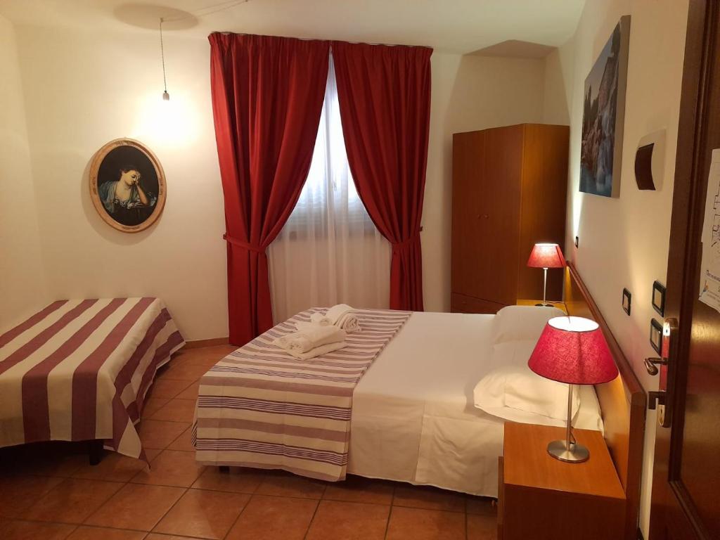 蒙特梅拉诺8380 camere Mastro的一间卧室配有床和红色窗帘的窗户