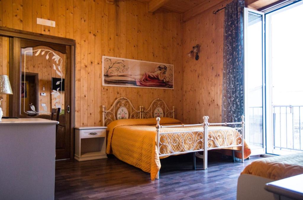 科佩尔蒂诺La Teresa B&B的卧室配有一张床铺,位于带木墙的房间内