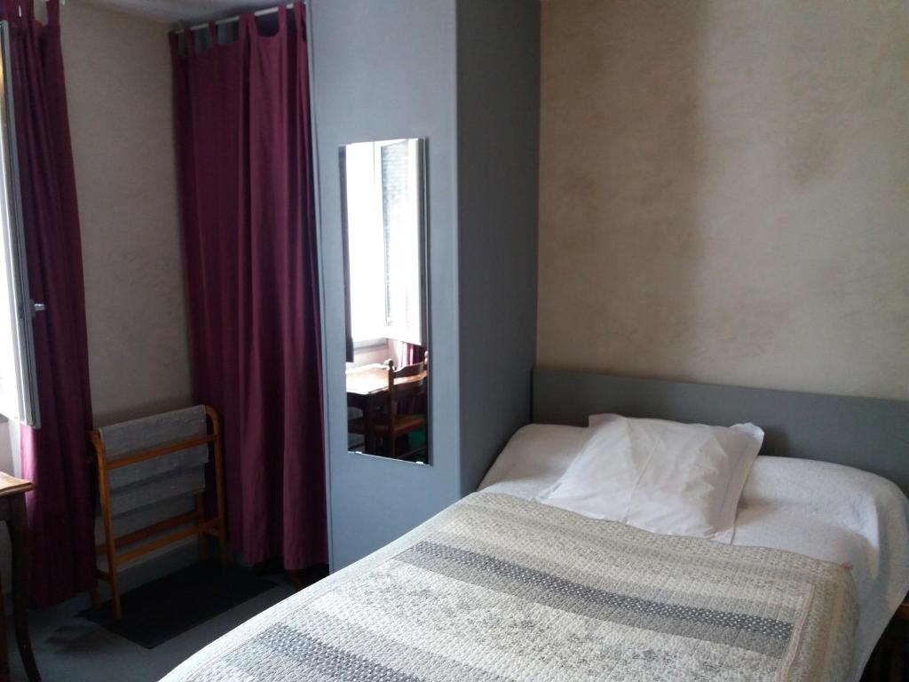 吕兹-圣索沃尔莱斯坦普来尔酒店的一间小卧室,配有一张床和镜子