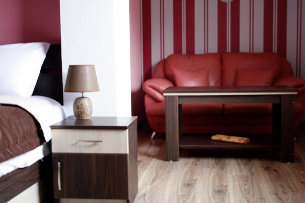卡赞勒克Guest House Bulgari的一间卧室配有红色的沙发和红色的椅子