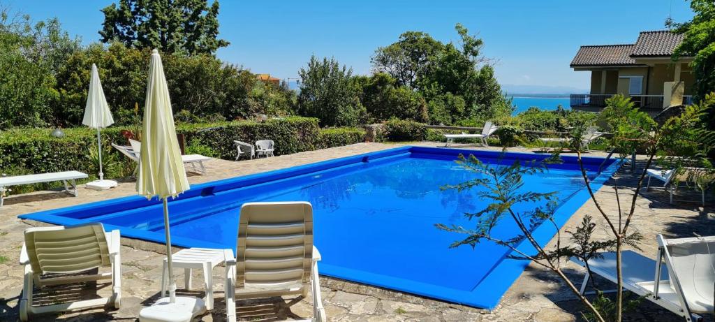 圣托斯特凡诺港Navarro Hill Resort的蓝色游泳池配有椅子和遮阳伞
