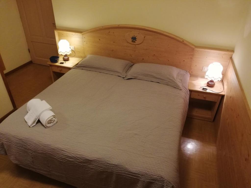奥伦佐卡多利CAMERE LARICE的一间卧室配有一张带2个床头柜的大床