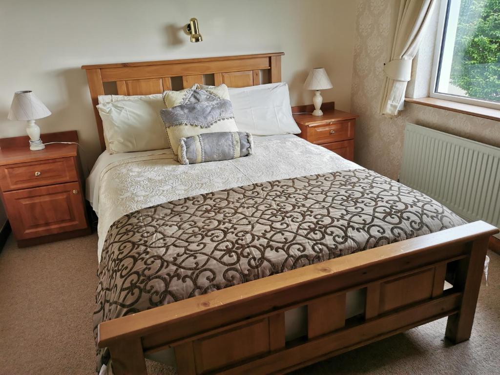 基拉尼Noraville House的一间卧室设有一张大床和两个床头柜