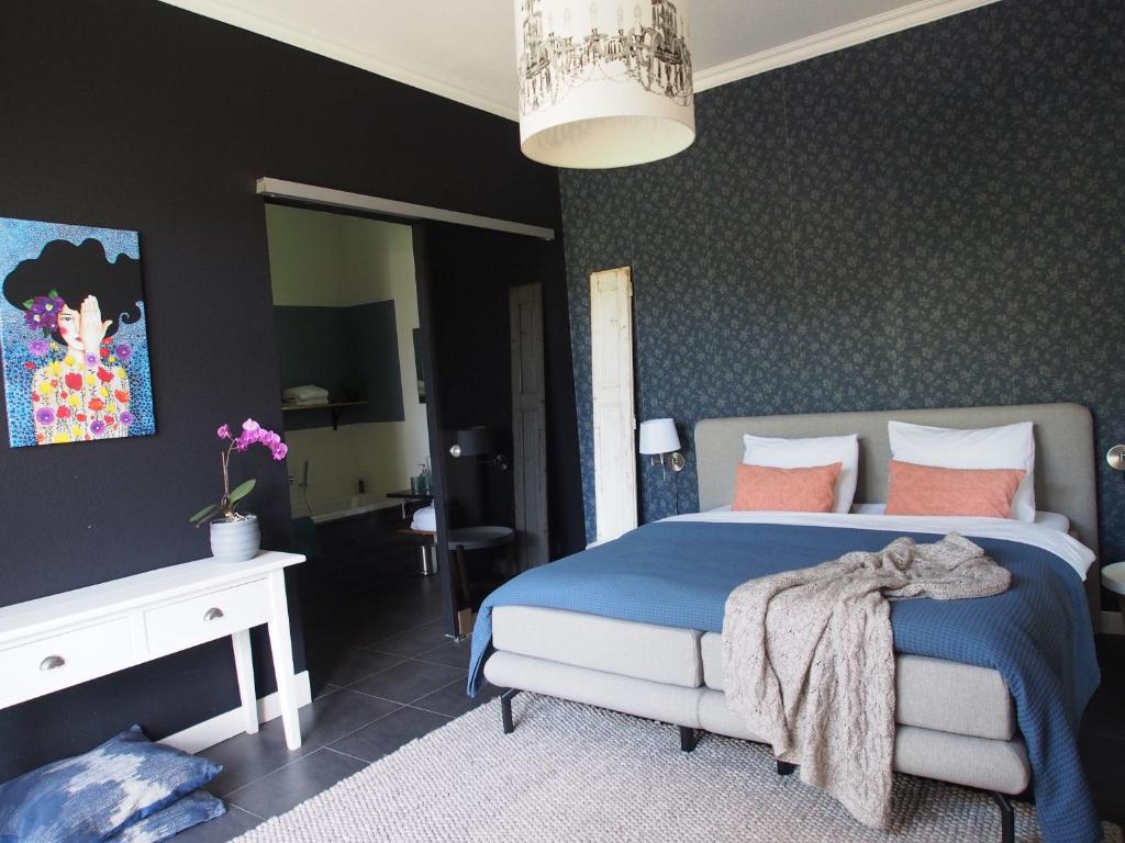 ZuidhornDe oude dokterspraktijk的一间卧室配有一张带蓝色床单和粉红色枕头的床。