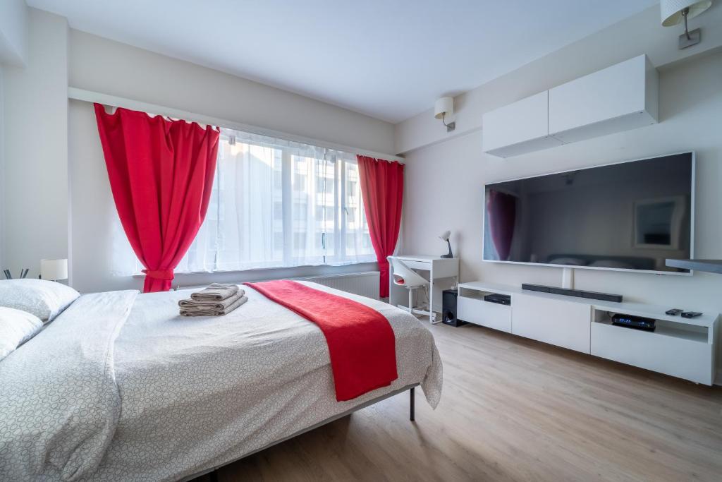 布鲁塞尔Luxury Studio In the EU Area的一间卧室配有一张带红色窗帘的大床