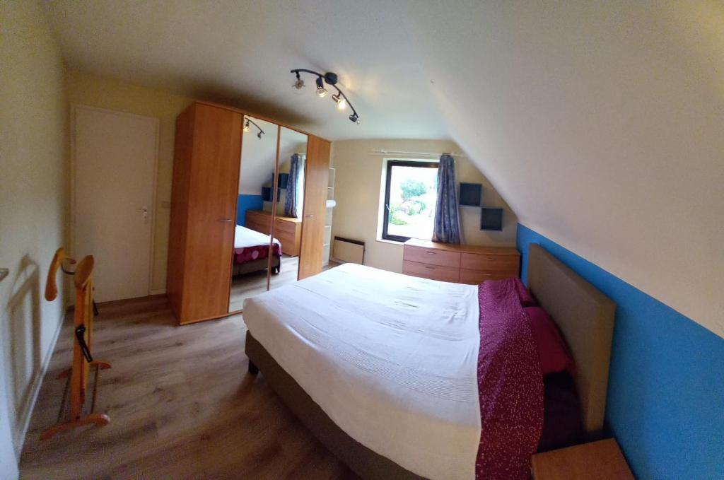 瓦夫尔Les prussiens的一间卧室设有一张蓝色墙壁的大床