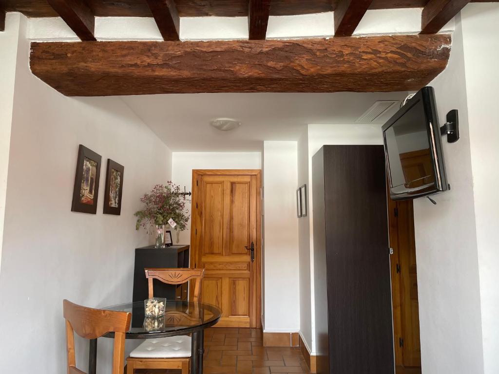 科尔多瓦Apartamento Corredera的一间设有桌子、电视和门的房间