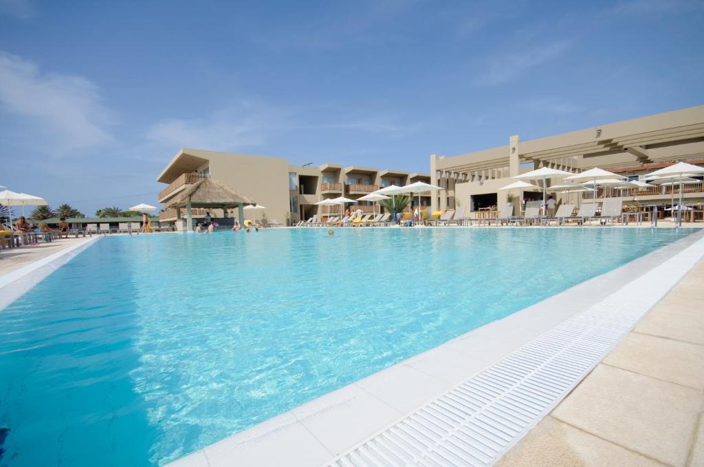 圣玛丽亚绿洲萨利纳斯海酒店的一座带蓝色水和遮阳伞的大型游泳池