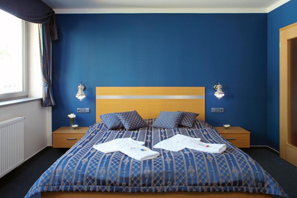 布拉格优卡拉酒店的蓝色卧室,配有带2条毛巾的床