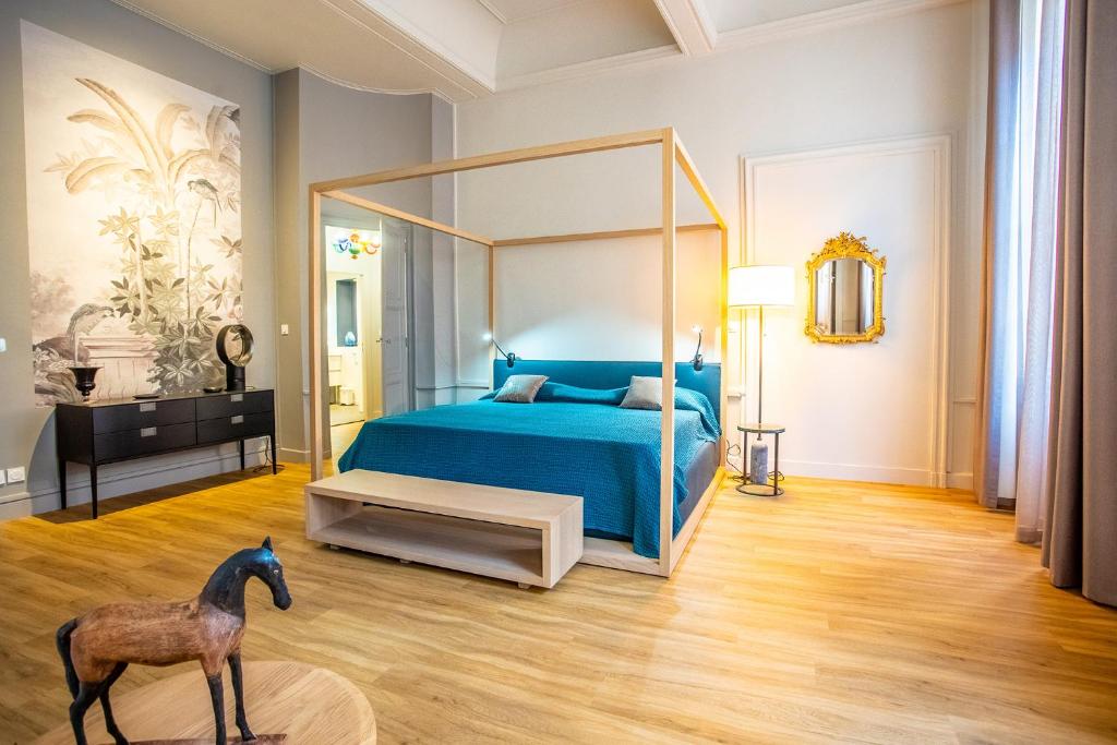 卡尔卡松Le Belem的一间卧室配有一张蓝色的床和马雕像