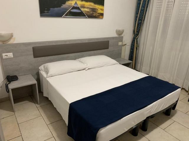 米兰阿丽桑德酒店的一间卧室配有一张带蓝白色毯子的床