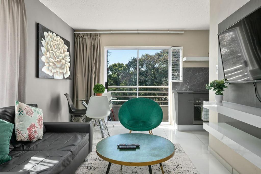 约翰内斯堡Marley on Katherine Apartments的带沙发和绿色椅子的客厅