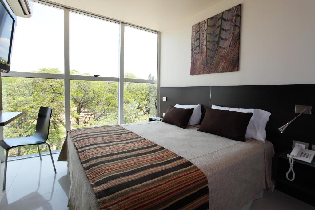 雷西斯膝西亚尼亚特城市酒店的一间卧室设有一张大床和大窗户