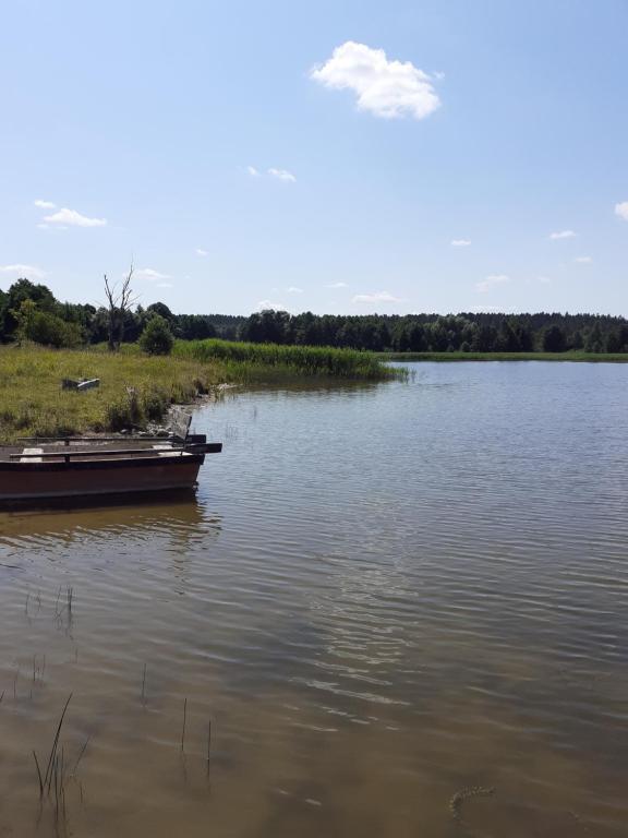 StręgielekDomek w sadzie na Mazurach的坐在湖水中的船
