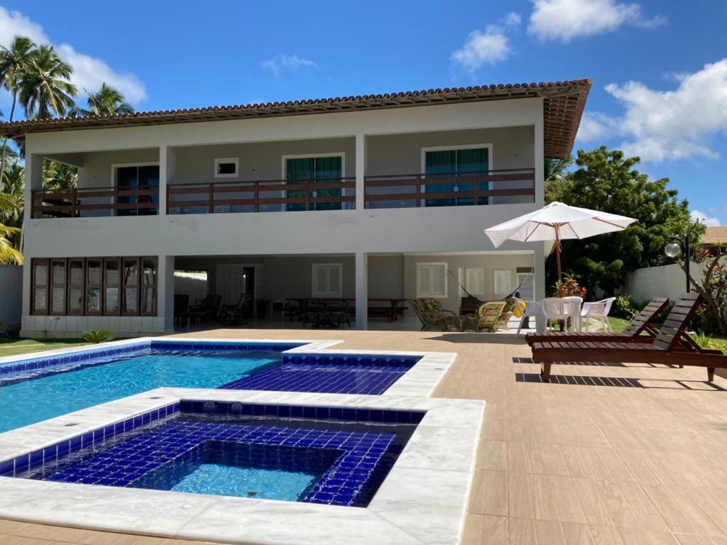 马拉戈日Ampla Casa na beira mar de Maragogi的一座带游泳池和房子的别墅