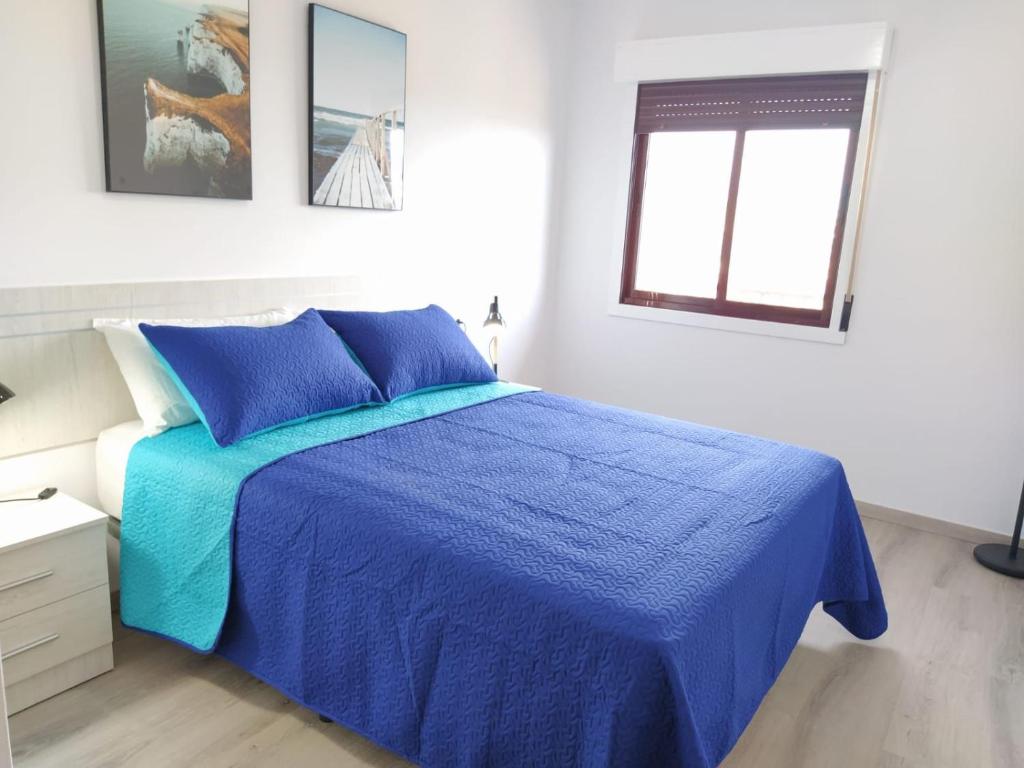 塔扎克蒂Ca L´Ana的一间卧室设有蓝色的床和窗户。