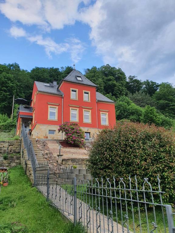 RathmannsdorfFerienwohnung "Möller"的前面有栅栏的红色房子