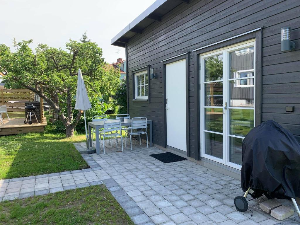 卡尔马Toppmodernt litet hus nära Kalmar slott och havet的一个带桌子和遮阳伞的庭院和一座房子