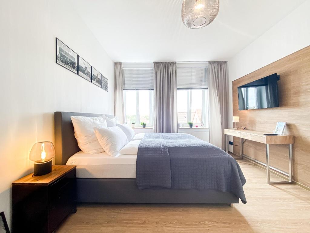 莱比锡Luxus-Apartment in Leipzig mit Privat-Parkplatz的一间卧室配有一张带书桌的床和窗户。
