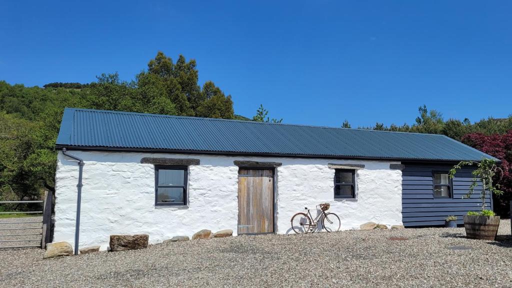 罗厄德南Loch Lomond Blair Byre的白色小屋,前面设有自行车停放处