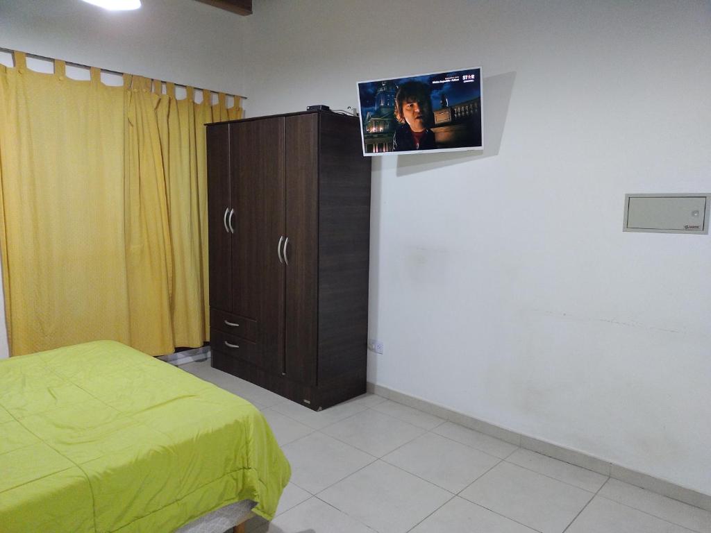 圣胡安Departamento Monoambiente Rivadavia的一间卧室配有一张床,墙上配有电视