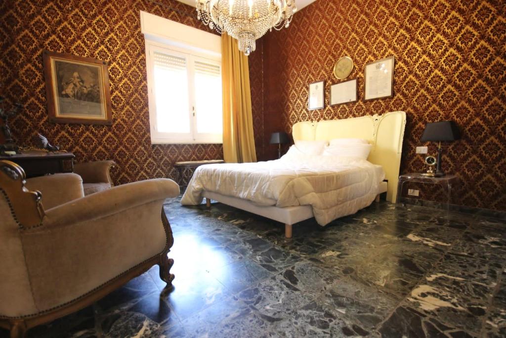 卡利亚里Il Chiostro的一间卧室配有一张床、一把椅子和一个吊灯。