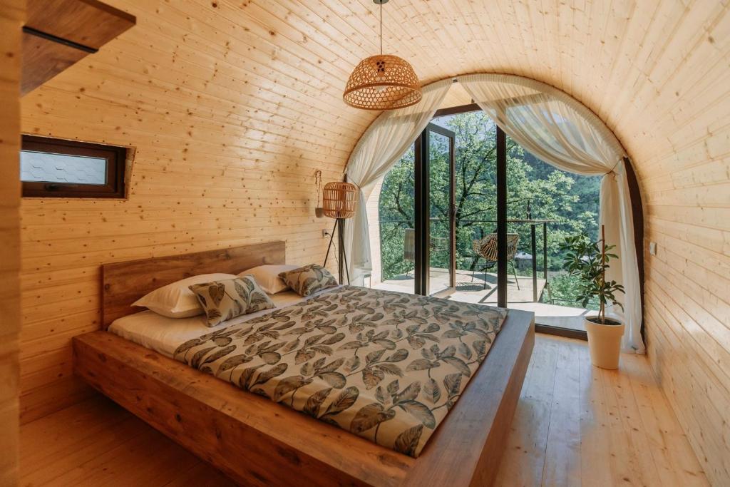 Zeda Ch'khutunet'iWoodhide - Cottages near Batumi, Georgia的一张位于带大窗户的房间内的床铺