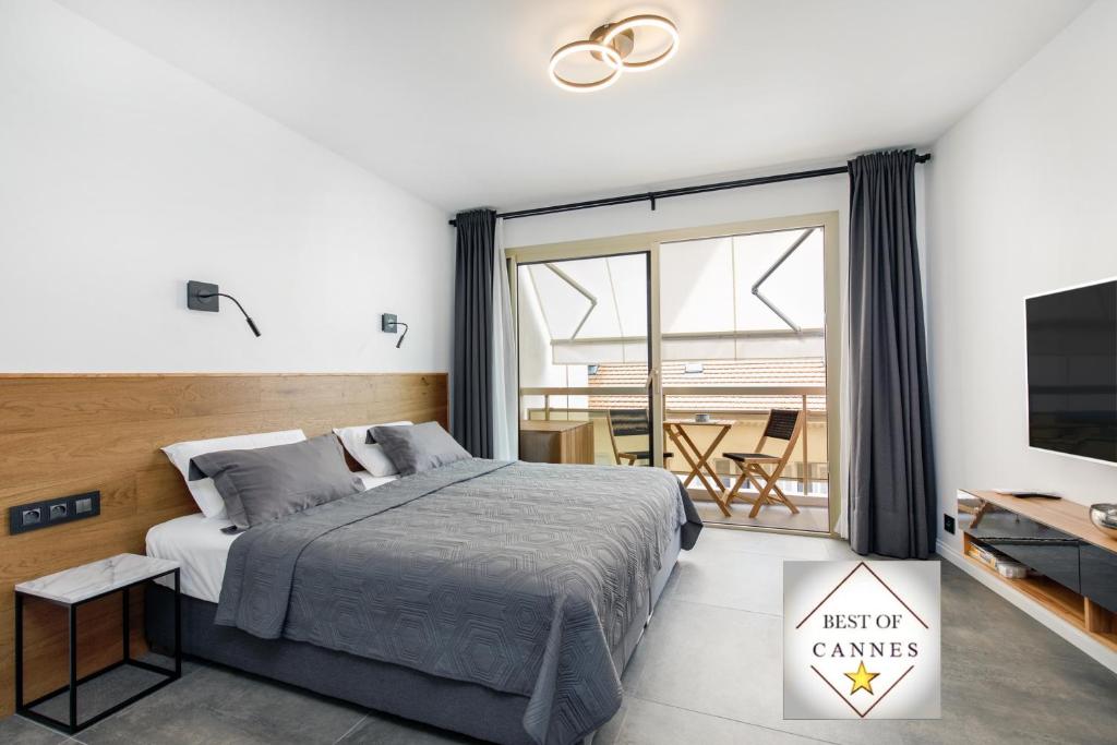 戛纳Cannes CROISETTE, Palais des Festivals, Beaches, Apart Residence Le MINERVE的一间卧室设有一张床、一台电视和一个阳台。