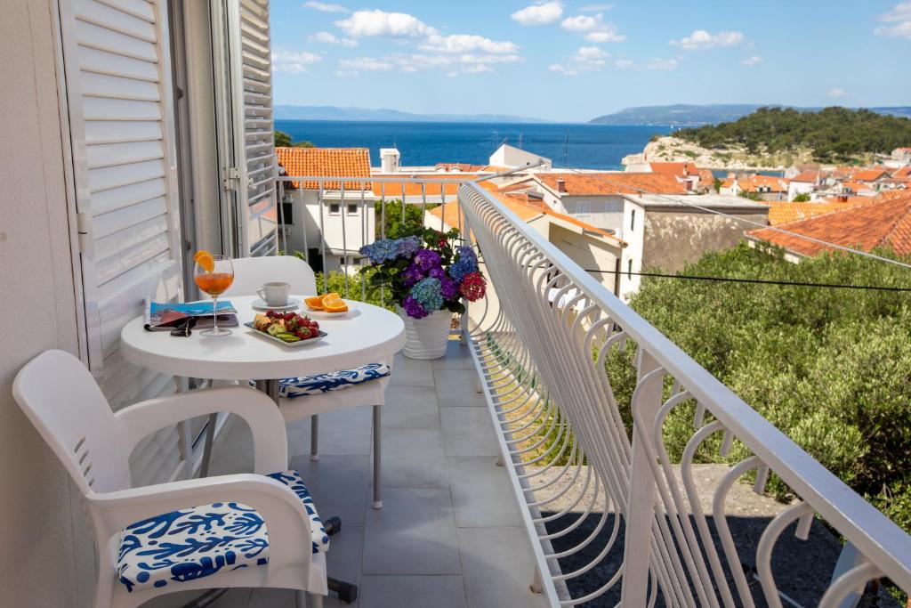 马卡尔斯卡Hortenzija Apartments的阳台配有桌椅,享有海景。