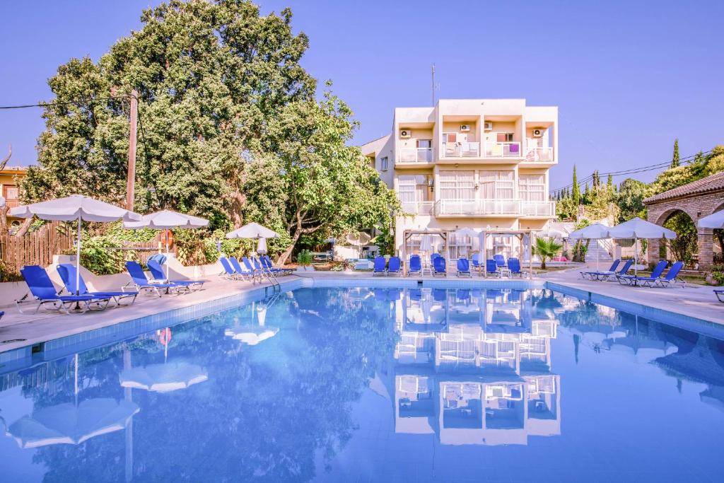 科孚镇Amalia Corfu Hotel的一座带蓝色椅子的游泳池和一座建筑