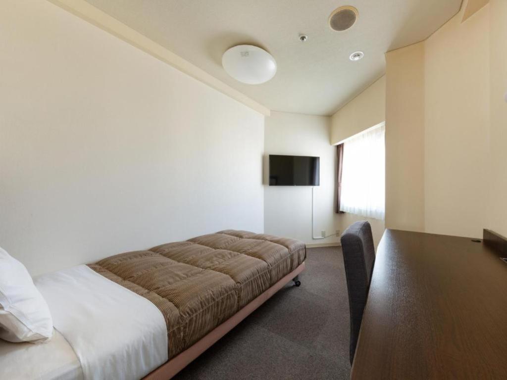 冈山The OneFive Okayama - Vacation STAY 41839v的一间卧室配有一张床、一张桌子和一台电视