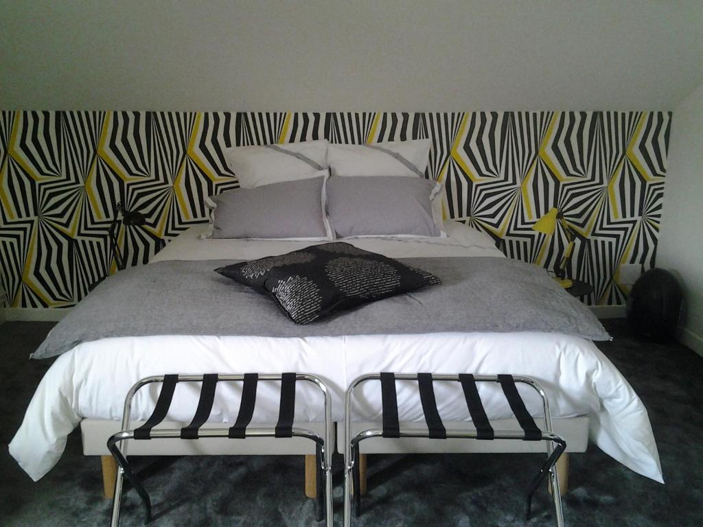 默兹河畔凡尔登La Maison Mirabeau的一间卧室配有一张大床和两把椅子