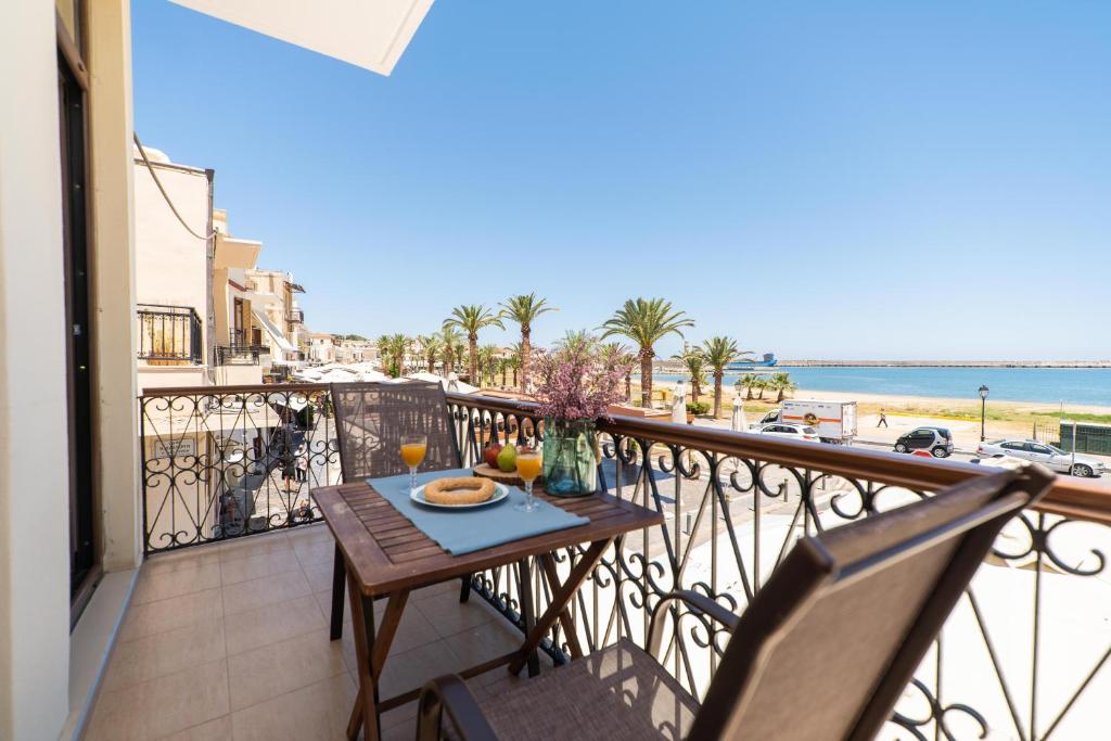 罗希姆诺Blue Sea Relax Apartment的海滩景阳台桌子
